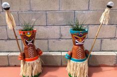 two native american style planters with grass in them, one is wearing a headdress