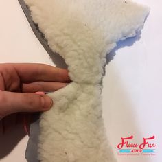 someone is cutting the end of a stuffed animal's neck tie with scissors and thread