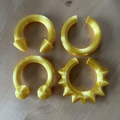 four pieces of yellow plastic sitting on top of a wooden table