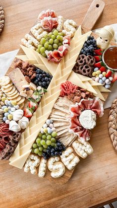 a wooden table topped with lots of different types of cheese and crackers on top of it