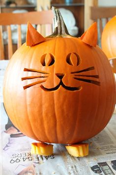 a carved pumpkin with a cat's face on it, sitting on a table