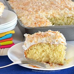 a piece of coconut cake on a plate with a fork next to the rest of the cake