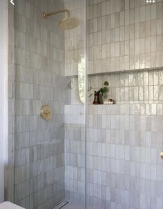 a white tiled bathroom with a walk in shower