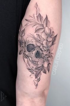 a woman's arm with a skull and flowers on it