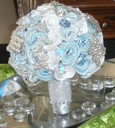 a bridal bouquet with blue and white flowers on a silver tray in front of a dresser