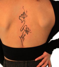 a woman's back tattoo with flowers on her left side and the word love written in cursive writing