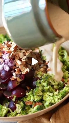 grapes, broccoli and almonds are being poured into a bowl with dressing