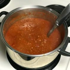 there is a pot on the stove with some food in it and two spoons