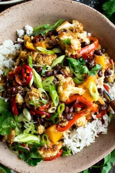 a bowl filled with rice and vegetables on top of a table