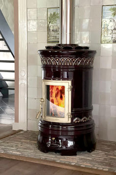 a wood burning stove sitting on top of a wooden floor next to a stair case