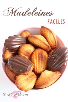 a bowl filled with chocolate covered cookies on top of a white tablecloth and the words madelienes facies written in french above it