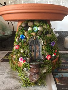 a potted planter with a statue in the center and moss growing around it