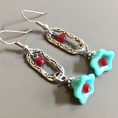 "Turquoise Red Earrings - Turquoise Czech Glass Flowers with Antiqued Silver Plated Beadcaps dangle from Decorative Antiqued Silver plated Pewter Ovals embellished with Czech Glass Red Crystals. The throat of the Turquoise flowers have Red Glass Crystals. Surgical Steel Earwires Earrings measure 2\" from top of earwires to bottom of flowers." Red Whimsical Nickel-free Earrings, Whimsical Red Nickel-free Earrings, Whimsical Red Jewelry With Matching Earrings, Whimsical Red Drop Earrings, Unique Nickel-free Dangle Flower Earrings, Unique Nickel Free Dangle Flower Earrings, Whimsical Handmade Red Earrings, Whimsical Turquoise Nickel-free Earrings, Whimsical Handmade Turquoise Earrings