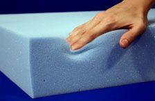 a person's hand on top of a foam mattress