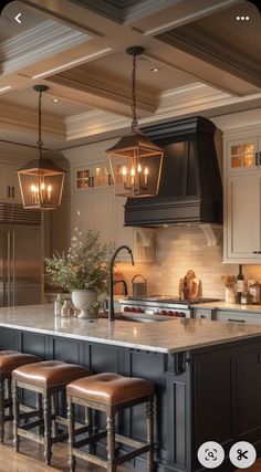 a kitchen with an island and stools in the center, lights hanging from the ceiling