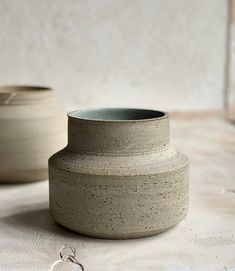 two vases sitting on top of a table next to each other