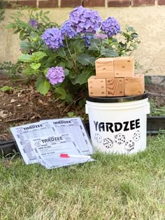 the yardze bucket is next to some purple flowers