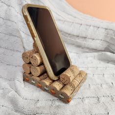 a cell phone is sitting on top of some wine corks that are stacked together