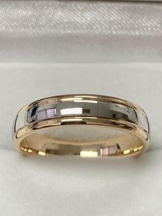 two tone gold wedding band with white and black inlays on the inside of it