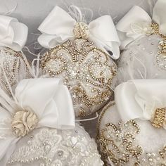 three white christmas ornaments with bows and sequins