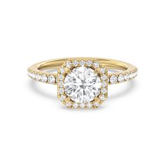 a yellow gold engagement ring with an oval cut diamond in the center and pave set shoulders