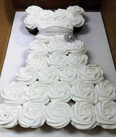 a wedding dress made out of cupcakes on top of a cake sheet with white icing