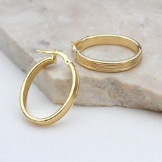 PRODUCT DESCRIPTION * Our 9ct Yellow Gold Ribbed Oval Hoop Creole Earrings make a stunning addition to any fine jewellery collection. These solid gold, everyday oval hoops feature a unique ribbed design that adds a touch of elegance. Perfect as a gift for a wife, girlfriend, sister, daughter, or friend, they make a thoughtful present for any occasion, including a golden anniversary.  * These textured hoops offer a modern twist on classic women's gold hoop earrings, making them versatile enough t Gold Oval Huggie Earrings, Classic Gold Oval Huggie Earrings, Classic Gold Plated Oval Hoop Earrings, Classic Oval Gold Plated Hoop Earrings, Classic Oval Gold-plated Hoop Earrings, Gold Diamond Cut Oval Hoop Earrings, Gold Oval Diamond Cut Hoop Earrings, Oval Gold Hoop Earrings With Diamond Cut, Gold Plated Oval Huggie Earrings