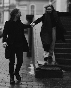 black and white photograph of two people walking down the street with their hands in each other's pockets