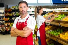 a man and woman are standing in front of the produce section of a grocery store - stock photo - images