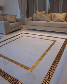 a living room with couches, chairs and a rug on the floor in front of windows