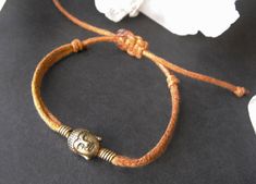 This brown cord bracelet has a bronze tone Buddha head charm and is wrapped with bronze tone wire each side of the charm. It is fully adjustable in size using a hand tied macramé flat knot from 15 cm (6 inches) wrist size opening up to 28 cm (11 inches) to allow to slip over the hand. Need Something Changing? If you prefer a different cord colour or size just get in touch. Also see our other designs in our cord bracelet section: https://www.etsy.com/shop/DimensionsLimousin?ref=profile_header§ion Buddha Head, Profile Header, Limousin, Cord Bracelet, Cord Bracelets, Organza Gift Bags, Star Patterns, Charm Bracelets, 11 Inches