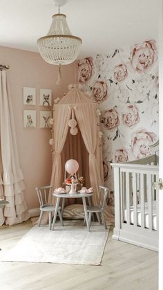 a baby's room with pink flowers on the wall