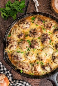 a casserole dish with meatballs and cheese in it on a wooden table