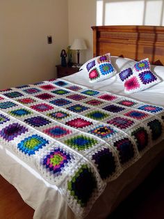 a bed with a crocheted blanket on top of it