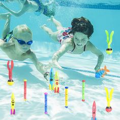 two children are swimming in the pool surrounded by plastic toy sticks and markers that spell out letters