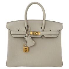 Hermes Birkin 25cm Beton, a classic netral color from Hermes, a creamy Ivory with some grey undertones Gold Hardware The Hermes Birkin is a luxury handbag from the fashion house Hermes. It is a variation of the iconic Hermes Birkin bag, which was first introduced in 1984 and has since become one of the most sought-after luxury handbags in the world. The Beton Birkin is a classic color , one of their prettiest neutrals. It is made from togo leather and features the signature Hermes lock and key closure, as well as the brand's signature Gold hardware. This particular Birkin has the most beautiful shape and togo leather, one of the best we have seen recently. The interior is lined with chevre and has a zip pocket with an Hermes engraved zipper pull and an open pocket on the opposite side. Col Hermes Birkin Bag, Cartier Panthere, Hermes Birkin 25, Fashion Vocabulary, Bracelet Love, Girly Bags, Hermes Box, Togo Leather, Kelly Bag