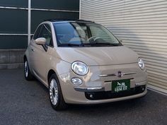 a small car parked in front of a garage door