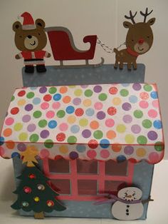 a paper house with reindeer and snowman on top