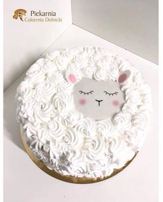 a cake decorated with white frosting and a sheep face