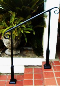 a potted plant sitting next to a metal hand rail