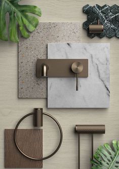 a bathroom with marble and brass fixtures on the wall next to a green leafy plant