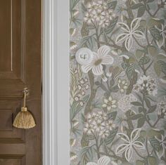 a wallpapered door with a tassel hanging from it