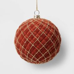 a red ball ornament hanging from a gold chain