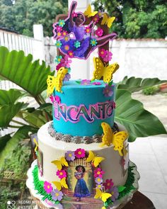 a three tiered cake decorated with princesses and flowers