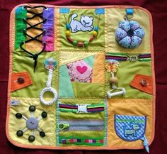 a close up of a quilt with various items on it, including beads and bracelets