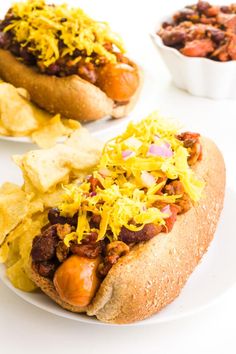 two hot dogs on buns with toppings and chips