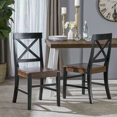 a dining room table with two chairs and a clock on the wall in the background