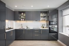 a modern kitchen with gray cabinets and white counter tops is seen in this image from the front view