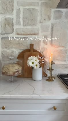 a kitchen counter with flowers and a candle on it that says what is your backsplash?