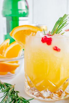 a drink with orange slices and rosemary garnish